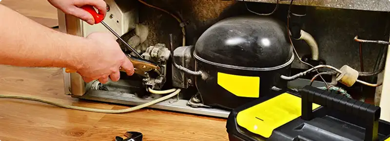 Refrigerator repair technician fixing the compressor and wiring in Longs, SC