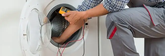 Dryer repair technician inspecting and repairing a clothes dryer in Myrtle Beach, SC