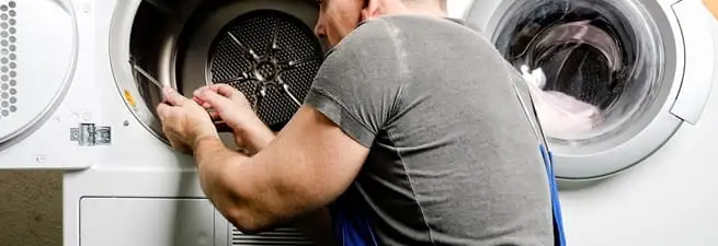 Dryer repair technician fixing a clothes dryer drum in Myrtle Beach, SC