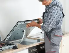 Appliance repair technician installing a built-in cooktop in Myrtle Beach, SC