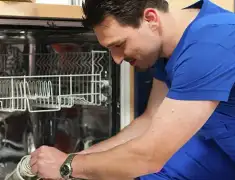 Dishwasher repair technician inspecting and servicing an open dishwasher in Myrtle Beach, SC