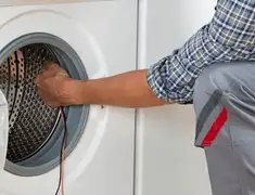 Dryer repair technician diagnosing and servicing a clothes dryer in Myrtle Beach, SC
