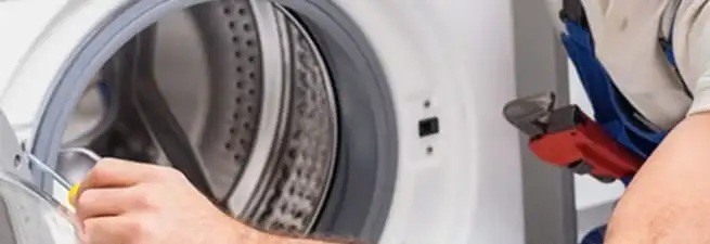Appliance technician repairing a clothes dryer drum and internal parts in Myrtle Beach, SC