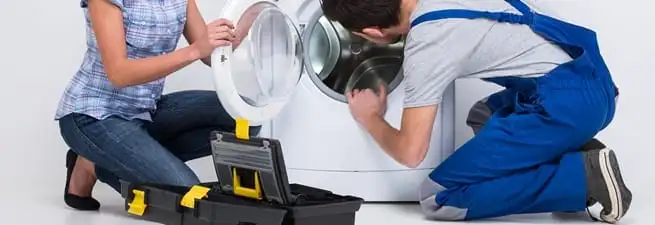Washer repair technician inspecting a front-load washing machine with tools in Myrtle Beach, SC