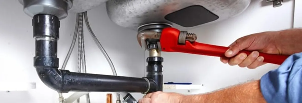 Garbage disposal repair technician tightening the sink drain and disposal connection in Myrtle Beach, SC