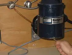 Garbage disposal repair technician tightening the mounting ring under a sink in Myrtle Beach, SC