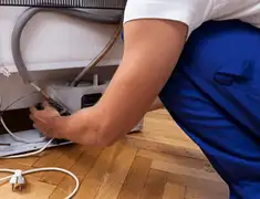 Appliance repair technician fixing refrigerator water line and connections in Myrtle Beach, SC