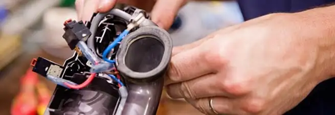 Vacuum repair technician reconnecting wiring and components in Myrtle Beach, SC