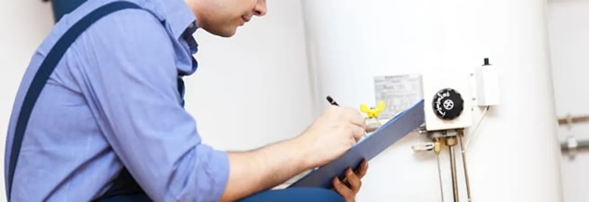 Water heater repair technician inspecting the unit and recording service notes in Myrtle Beach, SC