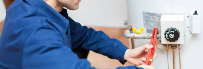 Water heater repair technician adjusting the temperature control and gas valve in Myrtle Beach, SC